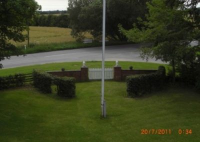 Et kig forbi flagstangen i haven på opholdsstedet Vangeledgård og ud på Daelsvej